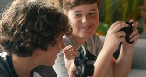Authentic moment between two young friends holding video game controllers Stock Footage 85373735