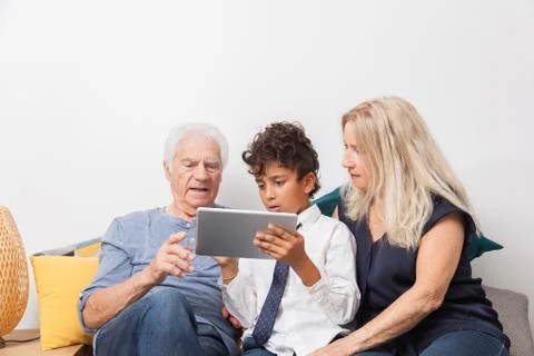 Authentic moment when boy with her grandmother and his grandfather play with  Foto stock