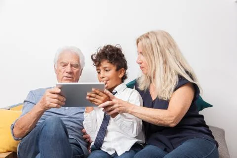 Authentic moment when boy with her grandmother and his grandfather play with  Foto stock