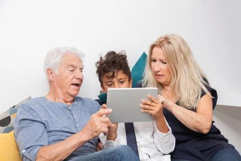 Authentic moment when boy with her grandmother and his grandfather play with  Foto stock