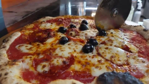 Authentic Neapolitan Pizza with Black Olives and Fresh Mozzarella being Sliced w Video stock 337676668