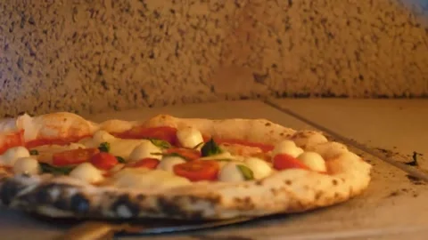 Authentic Neapolitan Pizza Margherita baking in traditional wood-fired brick ove Stockbeeldmateriaal 337676633