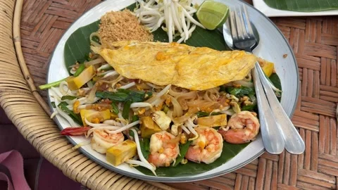 Authentic Pad Thai with Shrimp and Tofu on Rattan Table Stock Footage 331518157