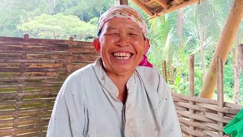 Authentic portrait of a cheerful elderly Asian woman farmer laughing happily. Stock Footage 321933588