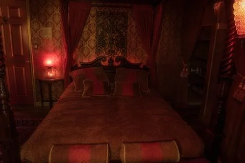 Authentic poster bed in a red victorian revival, bordello themed bedroom  Stock Photos
