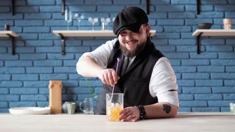 Authentic professional smiling bartender with tattoo creating a cocktail drink. Video stock 239162475