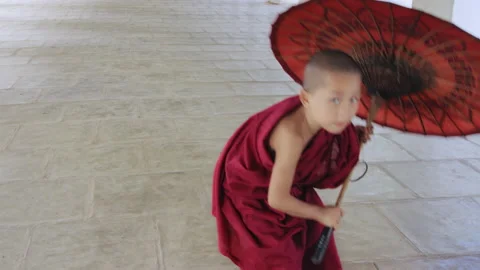 Authentic real monk boy holding bamboo umbrella smiling at camera In Bagan Mayan Stock Footage 201094844