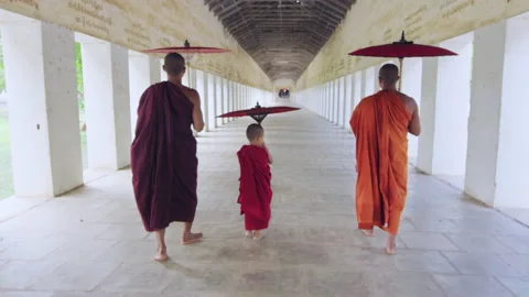 Authentic real monks walking in ancient passage way of temple with umbrellas, Ba Stock Footage 201095081