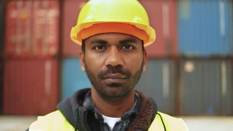 Authentic shot of Indian worker man looking at camera with containers box of Stock Footage 172384426