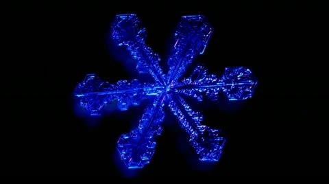Authentic snowflake rotating in blue lighting Stock Footage