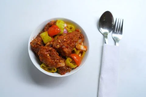 Authentic Sri Lankan Devil Chicken Curry in White Bowl with Utensils. Foto stock