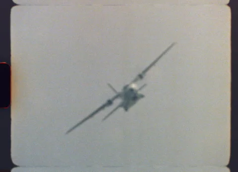 Authentic Super 8 film capturing a large military cargo airplane flying overhead 스톡 동영상 319875696