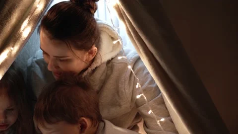 Authentic tender cute mom and preschool kids boy and girl in tent at home. young Stock Footage 147057406