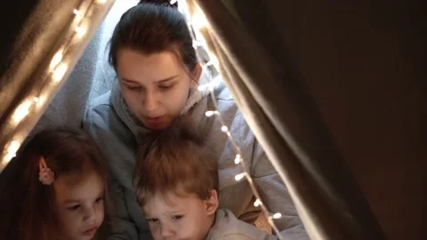 Authentic tender cute mom and preschool kids boy and girl in tent at home. young Stock Footage 147293322