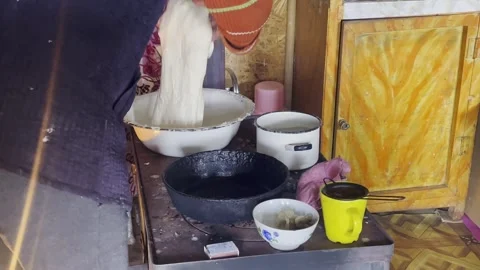 Authentic traditional bread making in Kyrgyzstan: a local kneads white dough in Видео 334177512