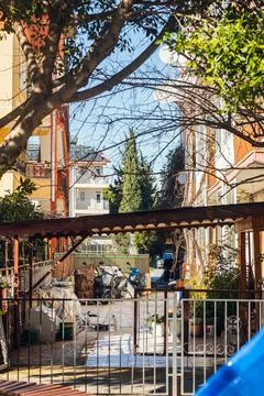 Authentic Turkish courtyard with a motorcycle, flower beds and a carport, con Stock Photos