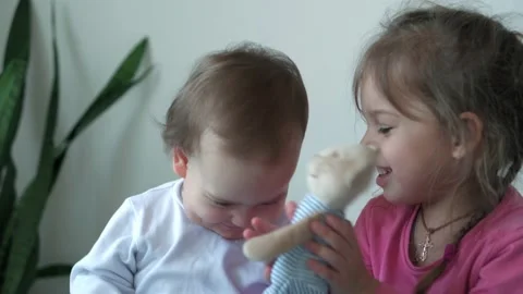 Authentic two joyful happy children, infant baby and 3-4 year old girl siting Stock Footage 150125397