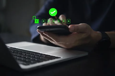 Authentication and secure login. A man is using his smartphone to verify a .. Stock Photos