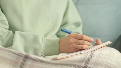 Author scribbles notes in a notebook. young woman with pencil writing to diary Stock Footage 221896457