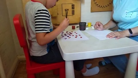Autistic boy draws with a brush and paints Stock-Footage 221742764