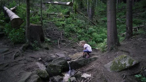Autistic boy playing in spruit Stock Footage 135385802