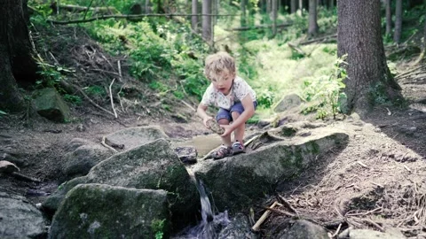 Autistic boy playing in spruit Stock Footage 135385941