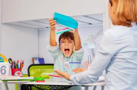 Autistic boy throws pens during development lesson Stock Photos