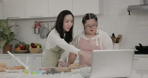 Autistic child practicing cake baking with mother in the kitchen at home Stock Footage 231768480
