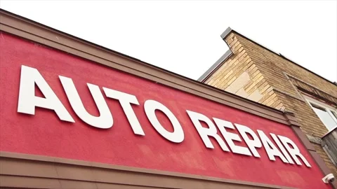 Auto body caption writing text white on red background mechanic shop, angle shot Stock Footage 246611320