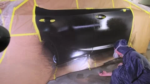 Auto body painter checking fresh clear coat with flashlight during vehicle Stock Footage 334862522