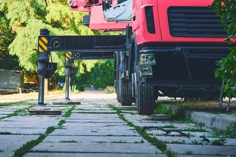 Auto crane red lifting machine stands on stops detends on the ground Stock Photos
