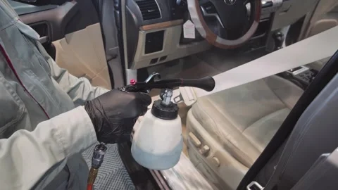 Auto detailing technician using a high-pressure tornado gun to deep clean a car Stock Footage 339992748