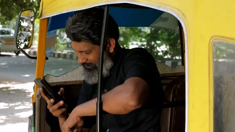 An auto-driver talking on phone during his rest time - lifestyle of an auto d... Video stock 258649311