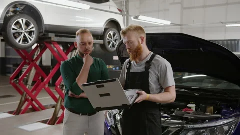 Auto electrician shows the detected errors to the manager Stock Footage 221548926