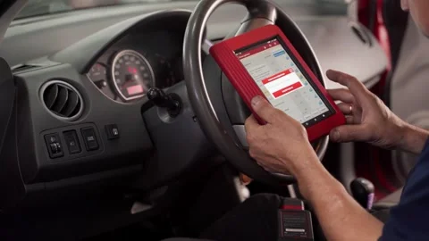 Auto electrician uses OBD2 scanner and tablet to diagnose vehicle faults Vídeos de archivo 270901592
