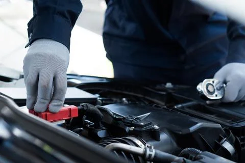 Auto machanic Checking and change the battery in garage. Repair service.Car.. Stock Photos