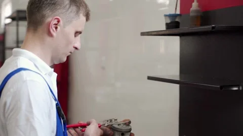 Auto mechanic assembles engine components in workshop. Precision installation of Stock Footage 272172371
