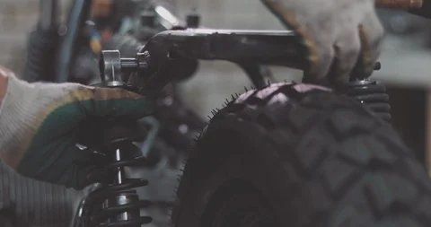 Auto mechanic assembles motorcycle in his workshop Stock Footage 94711077