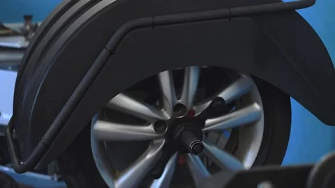 Auto mechanic balancing the car wheel  in a car service. Stock Footage 169944554