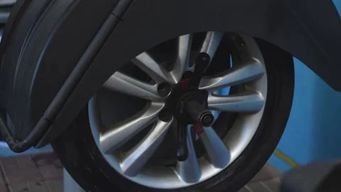 Auto mechanic balancing the car wheel  in a car service. Stock Footage 169944604