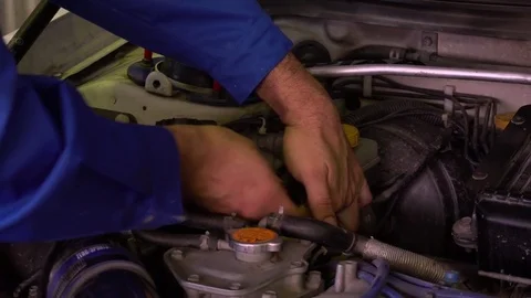 Auto mechanic in blue robe repairs the engine with a spanner in garage close-up Stock Footage 75686712