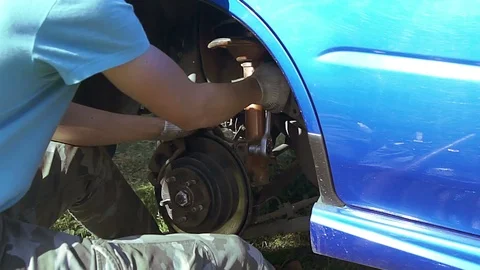 Auto mechanic changes shock absorber Stock Footage 73554640