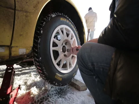 The auto-mechanic changes the wheel on the car, twists the bolts. Stock Footage 72401600
