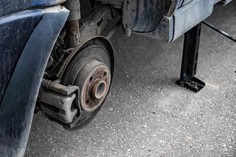 Auto mechanic changes wheel on old car. Stock Photos