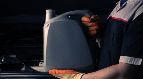Auto mechanic Changing engine oil or fuel from an engine lubricant bottle S.. Foto stock