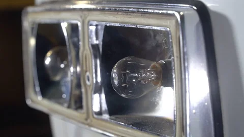 Auto mechanic changing light bulbs from the taillight of the car Stock Footage 127457516