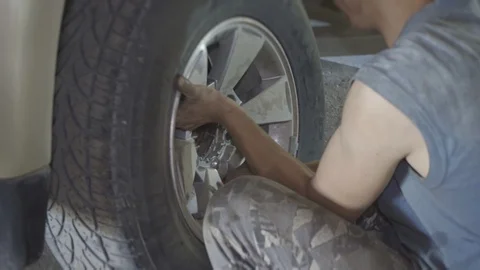 Auto mechanic changing wheel on car Stock Footage 126106277