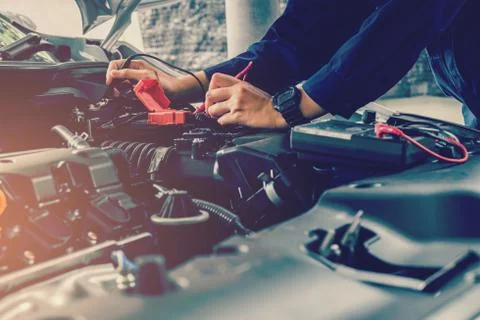 Auto mechanic checking car battery voltage Foto stock