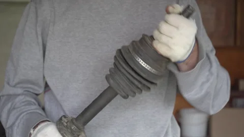 Auto mechanic checking a car CV joint boot on the drive shaft Stock Footage 332511074