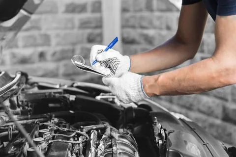 Auto mechanic checking car engine at the garage Stock Photos